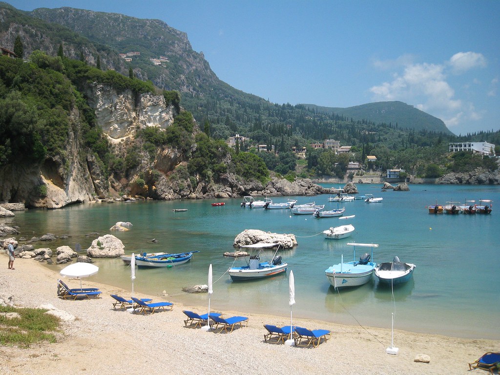 strand zee zon griekenland boter blauw water met bootjes en eiland