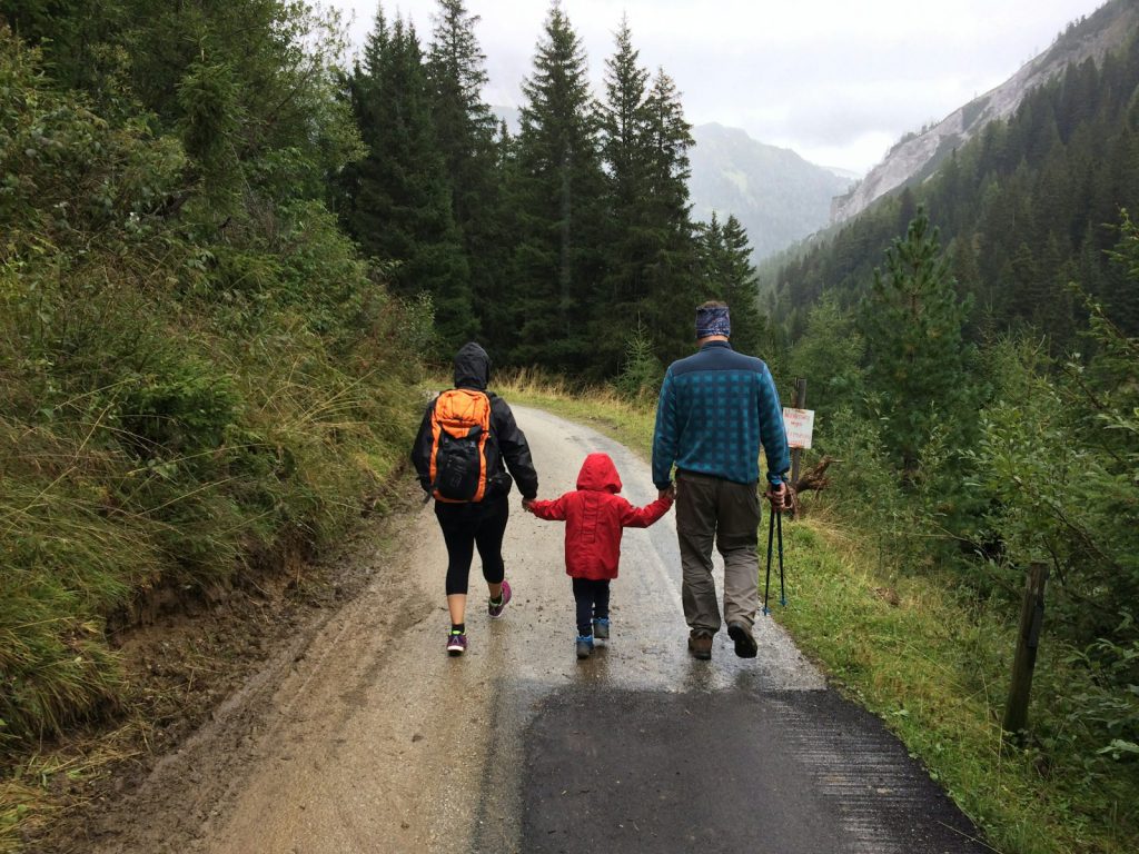 man, woman, and child walking together along dirt road savoie mont blanc