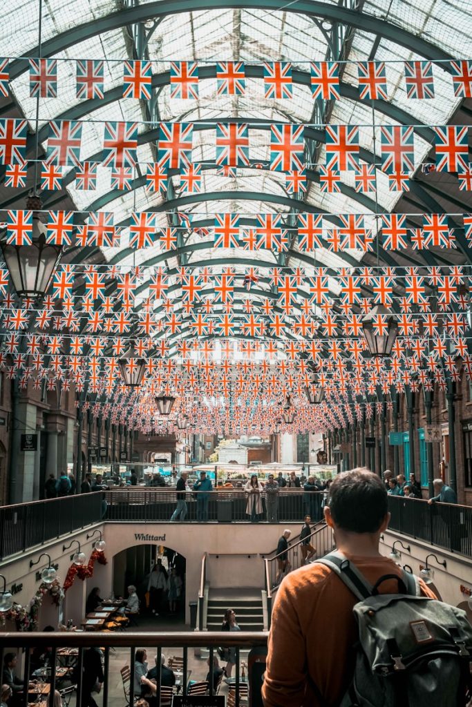 covent garden london a man standing in a building with a lot of flags hanging from the ceiling