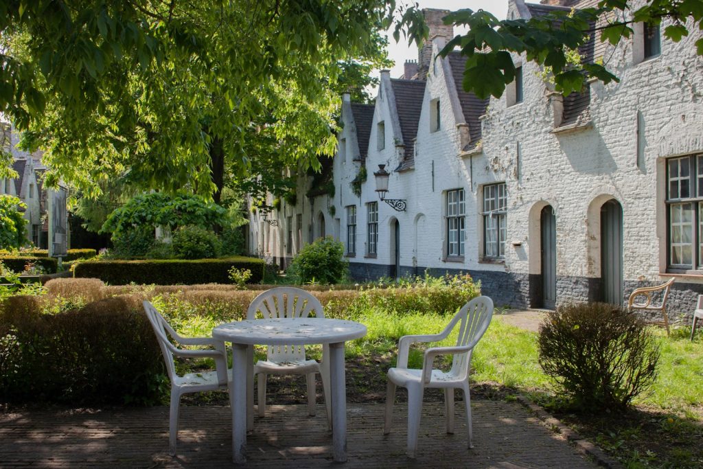 a couple of white chairs sitting next to a white table Brugge