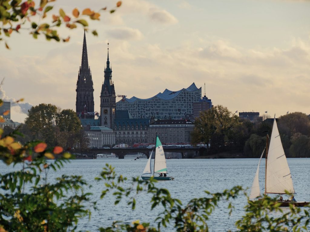 white sail boat on water near city buildings during daytime de leukste steden van duitsland hamburg