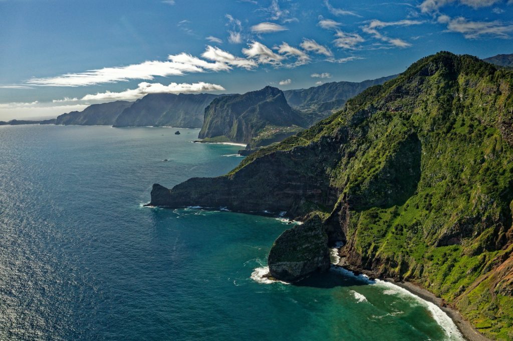 green and brown mountain beside body of water during daytime madeira winterzon in Europa