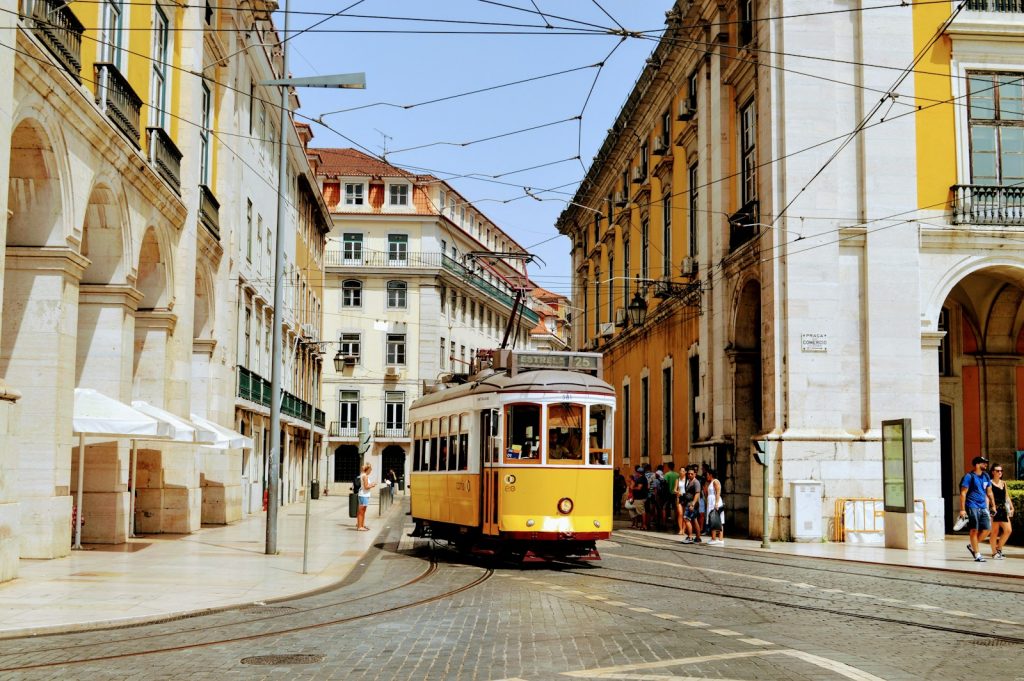 yellow and white tram on road during daytime de mooiste steden van portugal