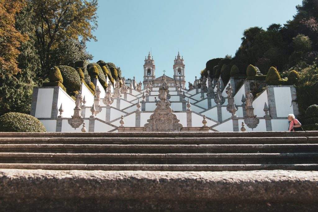 a person walking up some steps in front of a building de mooiste steden van portugal