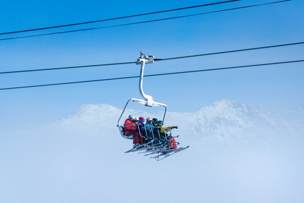 people riding on cable car during daytime ruzie op skivakantie